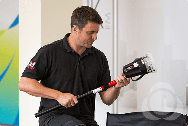A man operates a Solo 460 in-situ adaptor for smoke detector testing, ensuring functionality without removing the device.