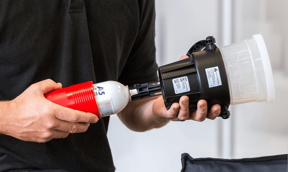 Demonstration of Solo detector tester in use, held by a professional for fire safety checks.